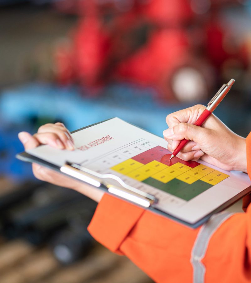 The manager is using ballpoint pen to marking on the risk assess